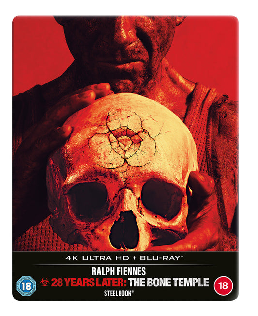 A person holding a cracked human skull against a vibrant red background.