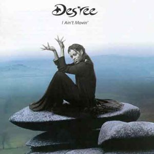 Des'ree album cover: woman in black seated on stones, blue background.