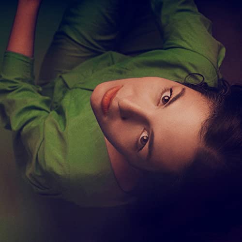 Close-up of a person lying down, looking up with eyes open.