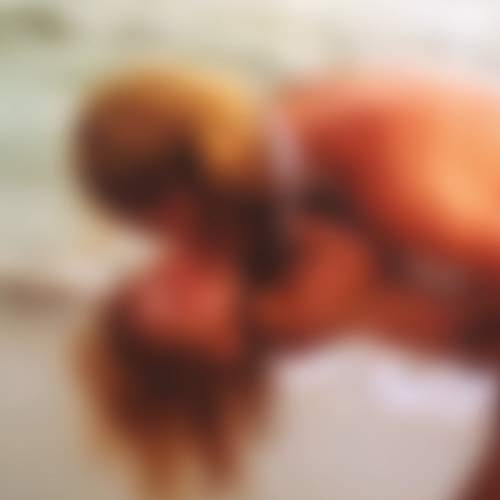 Blurred image of a vinyl record with reddish-brown tones.