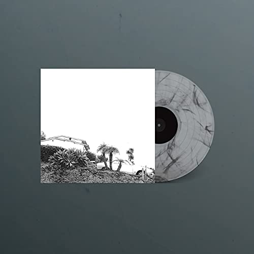 Vinyl record with smoke marble effect, next to album cover with landscape.