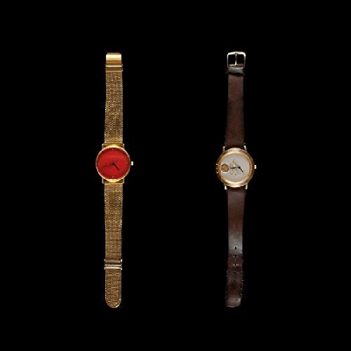 Two gold and brown wristwatches against a black background.