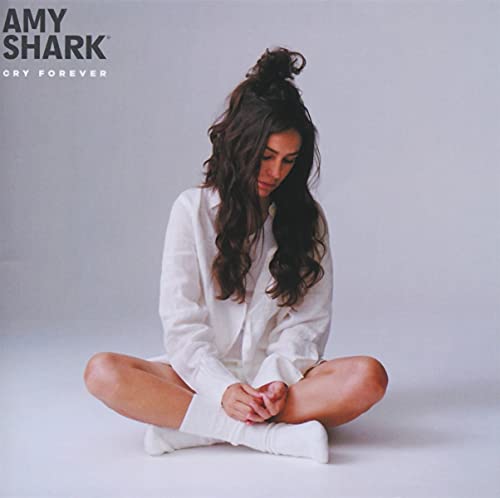 Amy Shark album cover: woman with long hair seated in white clothing.