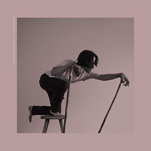 Black and white album cover featuring a person crouching with a ladder.