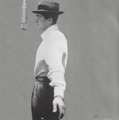 Black and white portrait of Dean Martin in a hat, singing into a microphone.