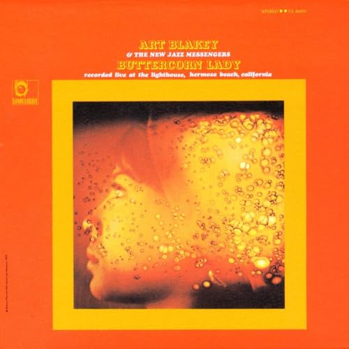 Orange album cover featuring a blurred portrait with golden speckles.