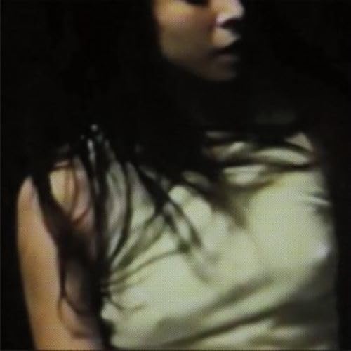 Dark, blurry portrait of a person with long dark hair.