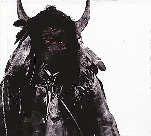 CD cover: Person with horns and feathers, dark and textured.