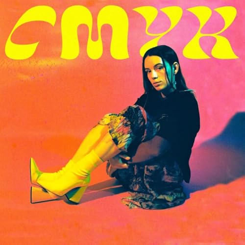 Person with colorful clothing and “CMYK” text on orange background.
