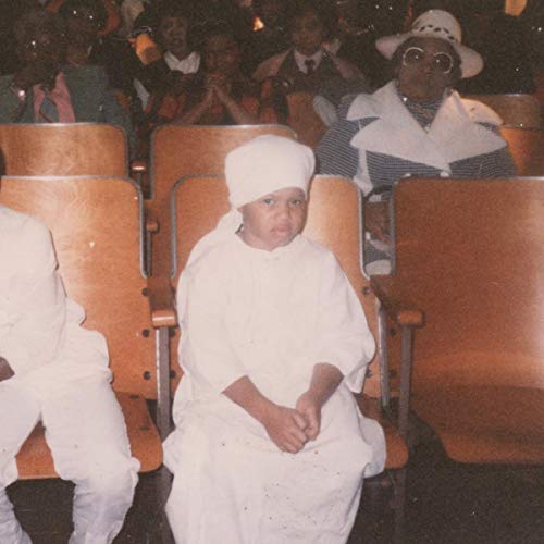 Angel Bat Dawid album cover featuring a seated woman in white, surrounded by people.