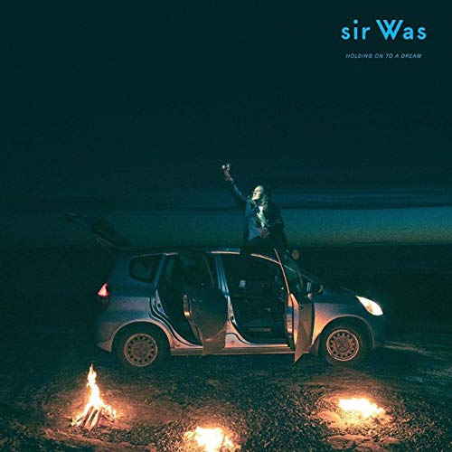 Album cover: person with raised hand by car and campfire.