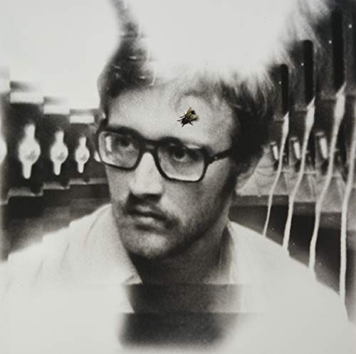 Black and white portrait of a man with a bug on his forehead.