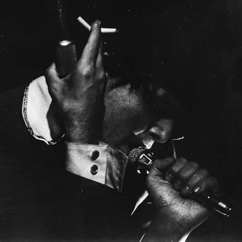 Black and white photo of a man singing into a microphone.