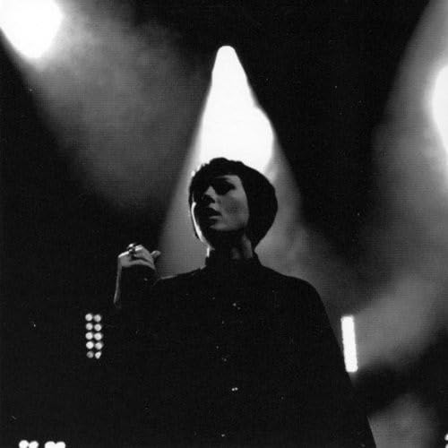 Black and white photo of a woman with dark hair performing onstage.