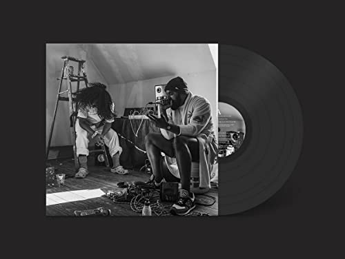Black and white photo of two people with a vinyl record.