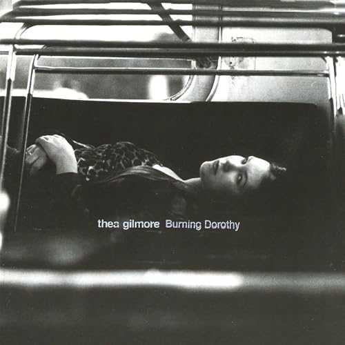 Black and white album cover featuring a woman lying within a vehicle.