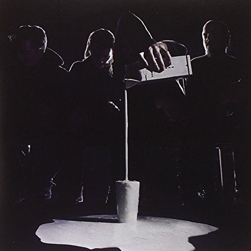 Dark album cover featuring four hooded figures and pouring white liquid.