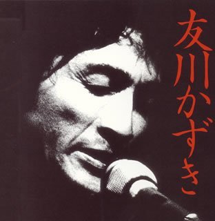 Close-up black and white portrait of Kazuki Tomokawa with red Japanese text.
