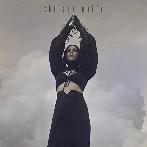 Chelsea Wolfe album cover: woman with hands raised against cloudy sky.