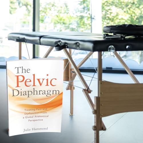 Book titled “The Pelvic Diaphragm” rests on a massage table indoors.