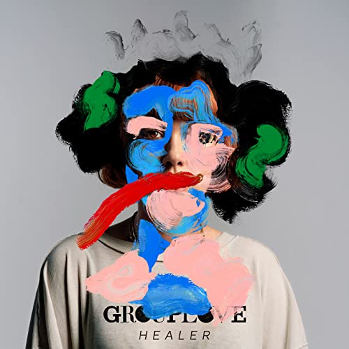 Person with colorful paint strokes obscuring face, album cover for Grouplove’s “Healer.”