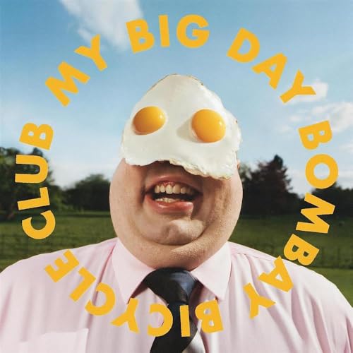 A man in a pink shirt with a fried egg on his face.