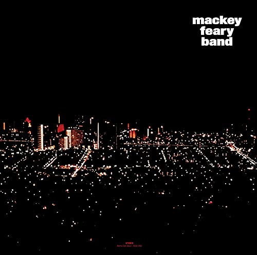 Night cityscape with glowing lights, text “mackey feary band” top right.