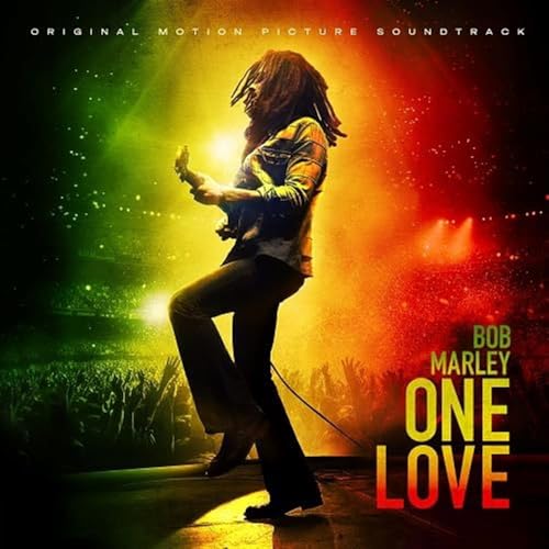 Bob Marley performing on stage with a green, yellow, and red background.
