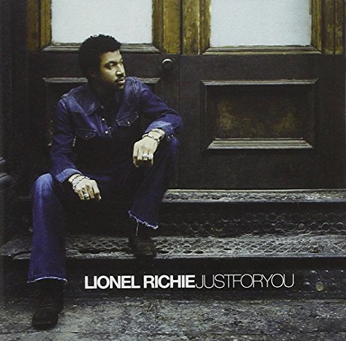 Lionel Richie album cover, seated man in denim, dark doorway background.