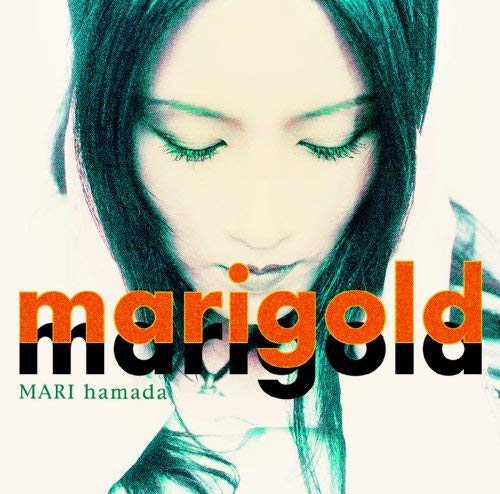 Close-up of Mari Hamada with downward gaze and orange text “marigold”.
