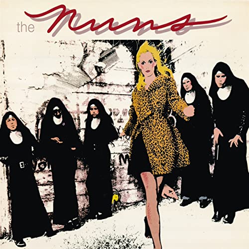 A blonde woman in a leopard-print coat walks past several nuns in black habits.