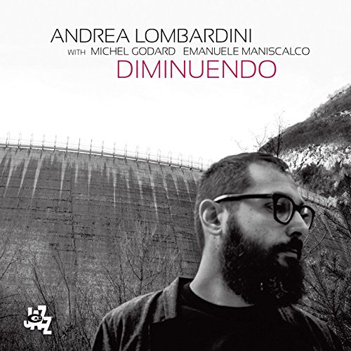 CD cover featuring portrait of bearded man and concrete dam landscape.