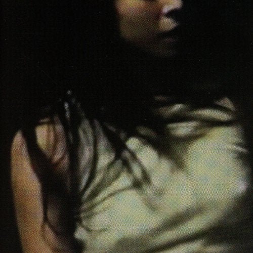 Dark, grainy portrait of a person with long dark hair, side view.
