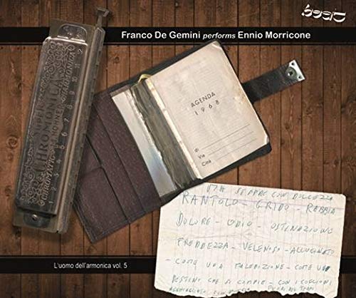 CD cover with harmonica, open notebook, and handwritten note on wood.