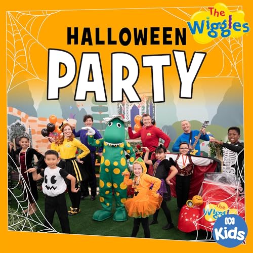 The Wiggles in Halloween costumes pose in front of a haunted house.