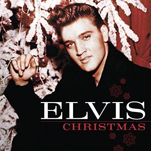 AlbumL album cover of Elvis Presley inL in a black coat byB beside white greenery.