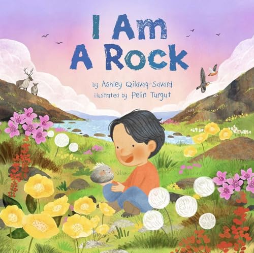 Child sitting in a field holding a small, textured rock.