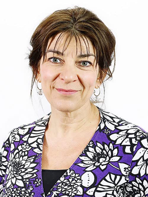 Headshot of a woman with brown hair wearing a purple floral top.