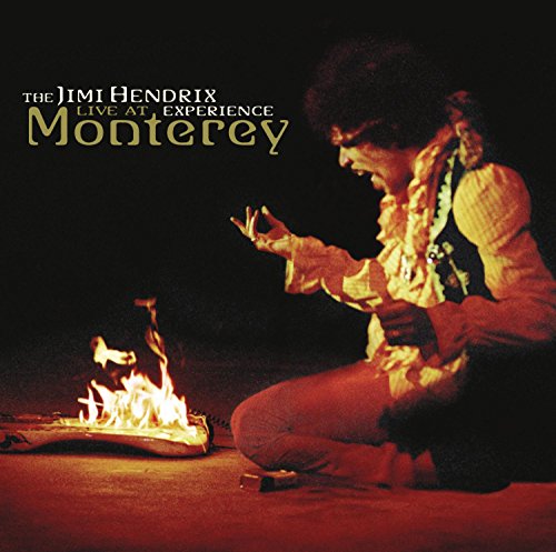Jimi Hendrix playing guitar, kneeling before a burning guitar onstage.