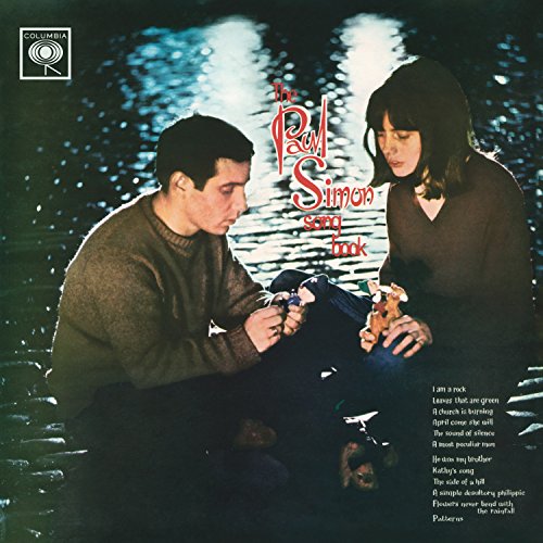 Paul Simon album cover featuring a couple by water with song titles listed.