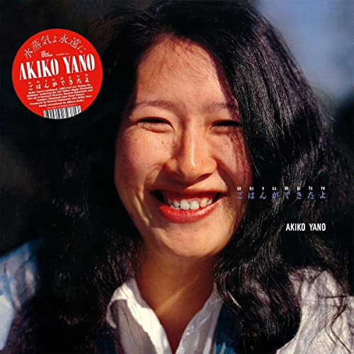 Akiko Yano album cover: smiling woman with dark hair, red sticker.
