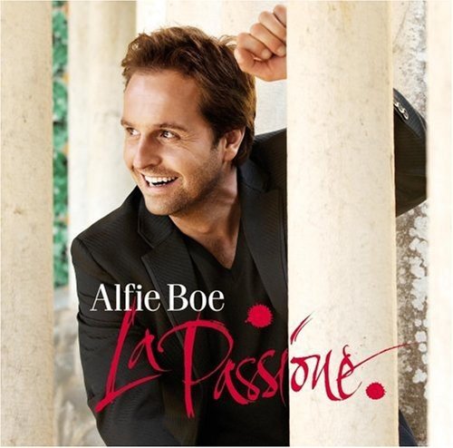 Alfie Boe smiling, wearing a black blazer, standing behind stone pillars on album cover.