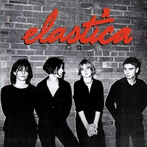 Black and white photo of Elastica band members in front of a brick wall.