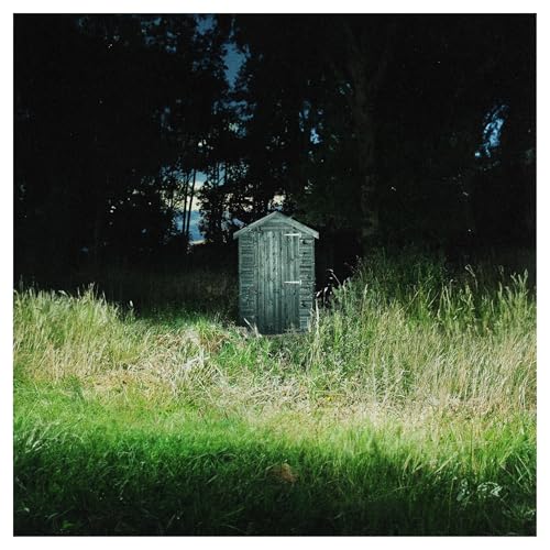 Dark Rainbow album cover: a weathered wooden outhouse in tall grass.