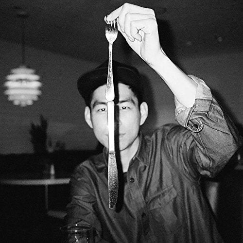 Black and white portrait of a person holding a fork and knife.
