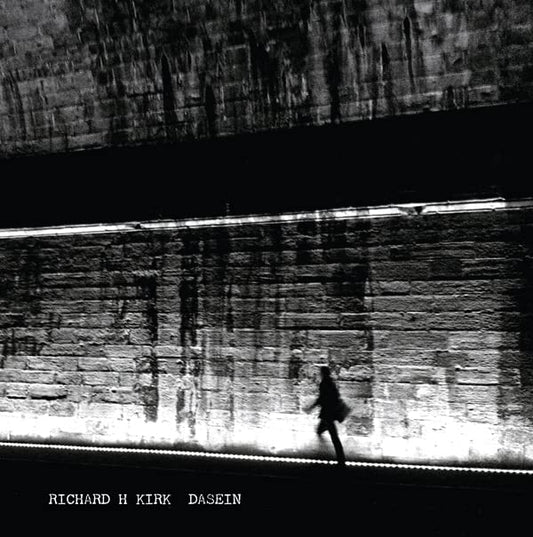 Black and white album cover with a blurred figure under a bridge.