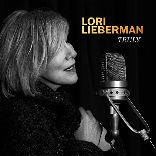 Black and white portrait of Lori Lieberman singing into a microphone.