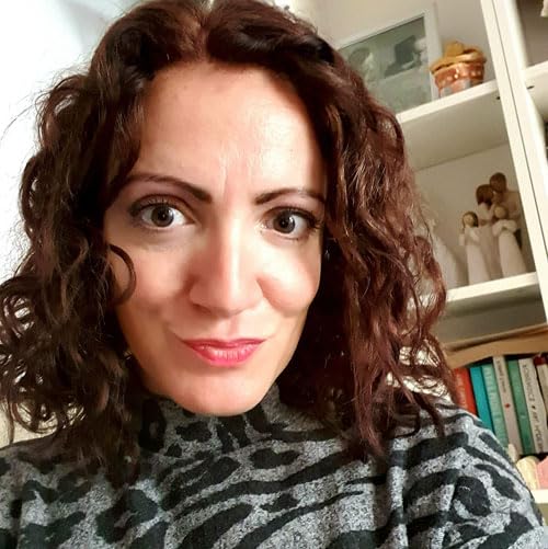 Close-up of a woman with long, curly brown hair and a neutral expression.