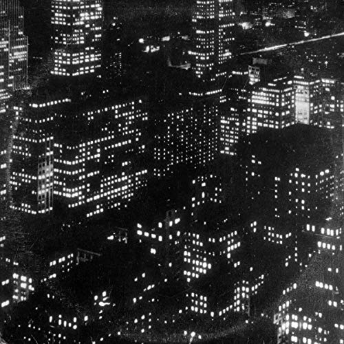 Black and white aerial view of illuminated city buildings at night.