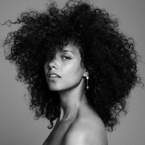 Black and white portrait of Alicia Keys with large, curly hair.